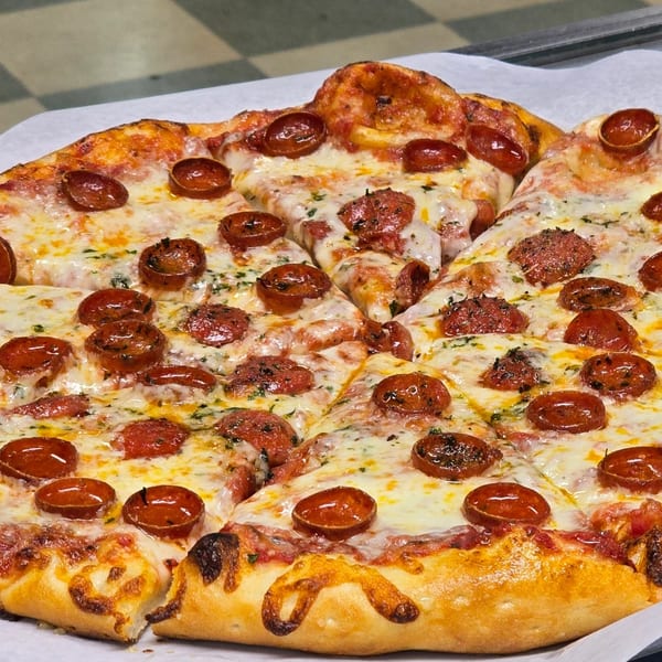 Close-up of a freshly baked pepperoni pizza from Only Pans, with melted cheese and crispy crust.