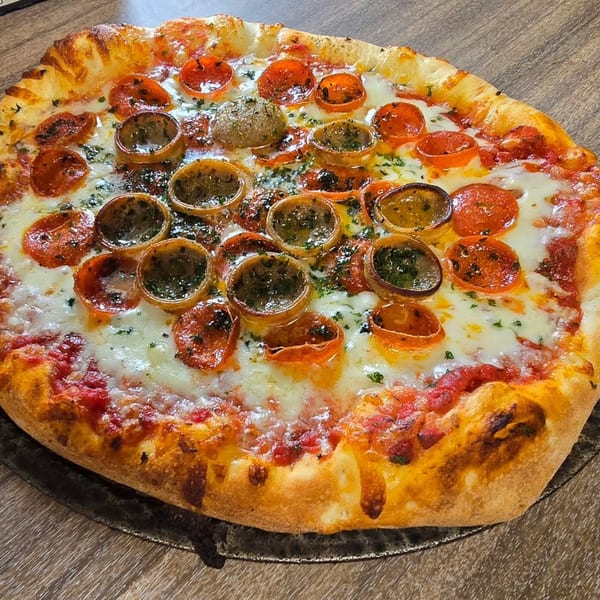 Only Pans pizza with pepperoni, cheese, and mushroom cups on a wooden table.